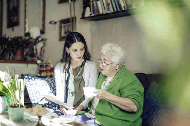 Toelichting rekentool huishoudelijke hulp en individuele begeleiding Begeleider kijkt met oudere vrouw naar administratie