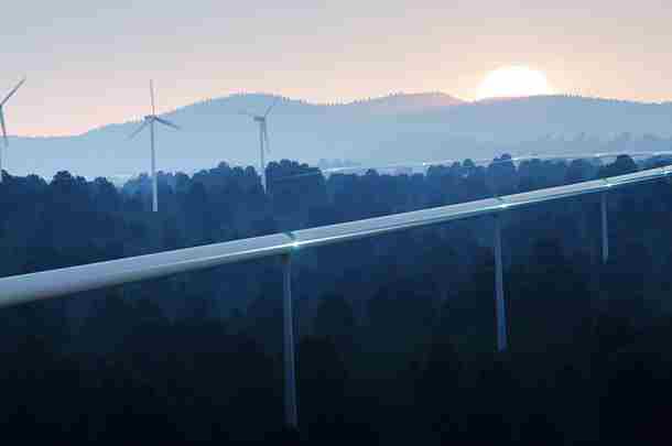 Hyperloop raast door landschap met ondergaande zon en windmolens